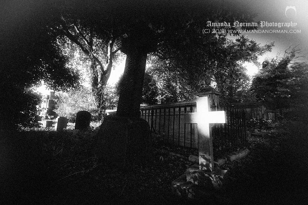 Light shining on crucifix in Kensall Green Cemetery
