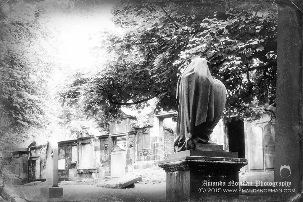 A photograph of a draped urn in an old graveyard