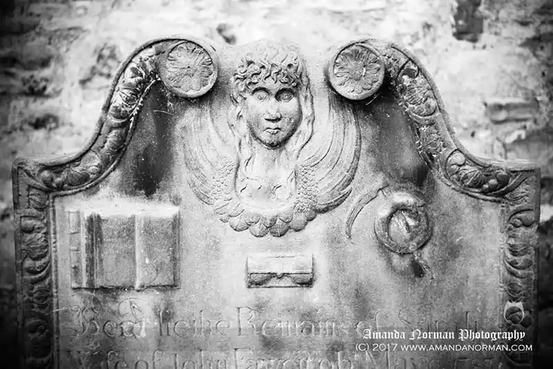 Image of a headstone showing memento mori symbols